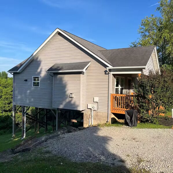 Ein zweistöckiges Haus mit Veranda und überdachtem Grillbereich.