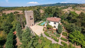 Una construcción que recuerda a un castillo, con piscina y jardines cuidados.