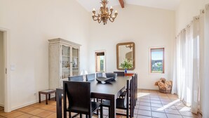 A dining area with a large table, chairs, a chandelier, a cabinet, and a mirror. - Luxury villa with pool close to the beach (Póvoa de Varzim)
