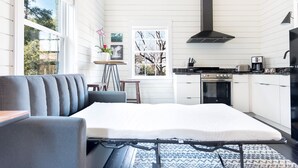 A modern kitchen with white cabinetry, a gas stove, and a black range hood. - Modern Farmhouse Style, 1 Block from Forsyth Park by Lucky Savannah (Savannah)