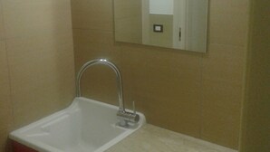 Ein Badezimmer mit einem weißen Waschbecken, einem Spiegel und einem roten Schrank.