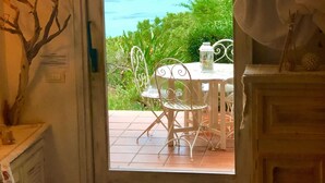 Una habitación con vista al mar, una mesa con sillas y una cama.