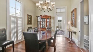 A dining room with a wooden table, six chairs, a chandelier, and a china cabinet. - Prime location: Walk to all the French Quarter attractions. Enjoy NOLA with ease (New Orleans)
