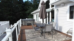 A covered patio with a table and chairs, a grill, and a white fence. - Beautiful Secluded Canalfront Home. Access to Private Beaches and Marina (Kitty Hawk)