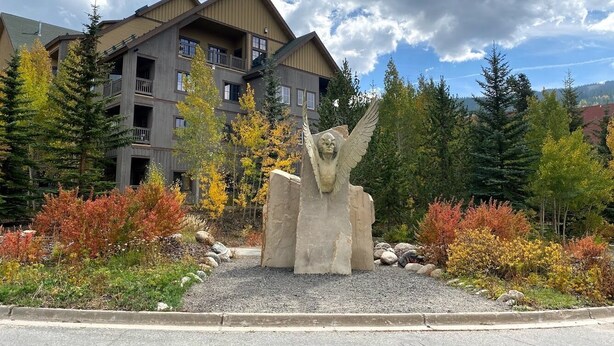 Un immeuble doté de nombreux balcons et orné d’une statue à l’avant.