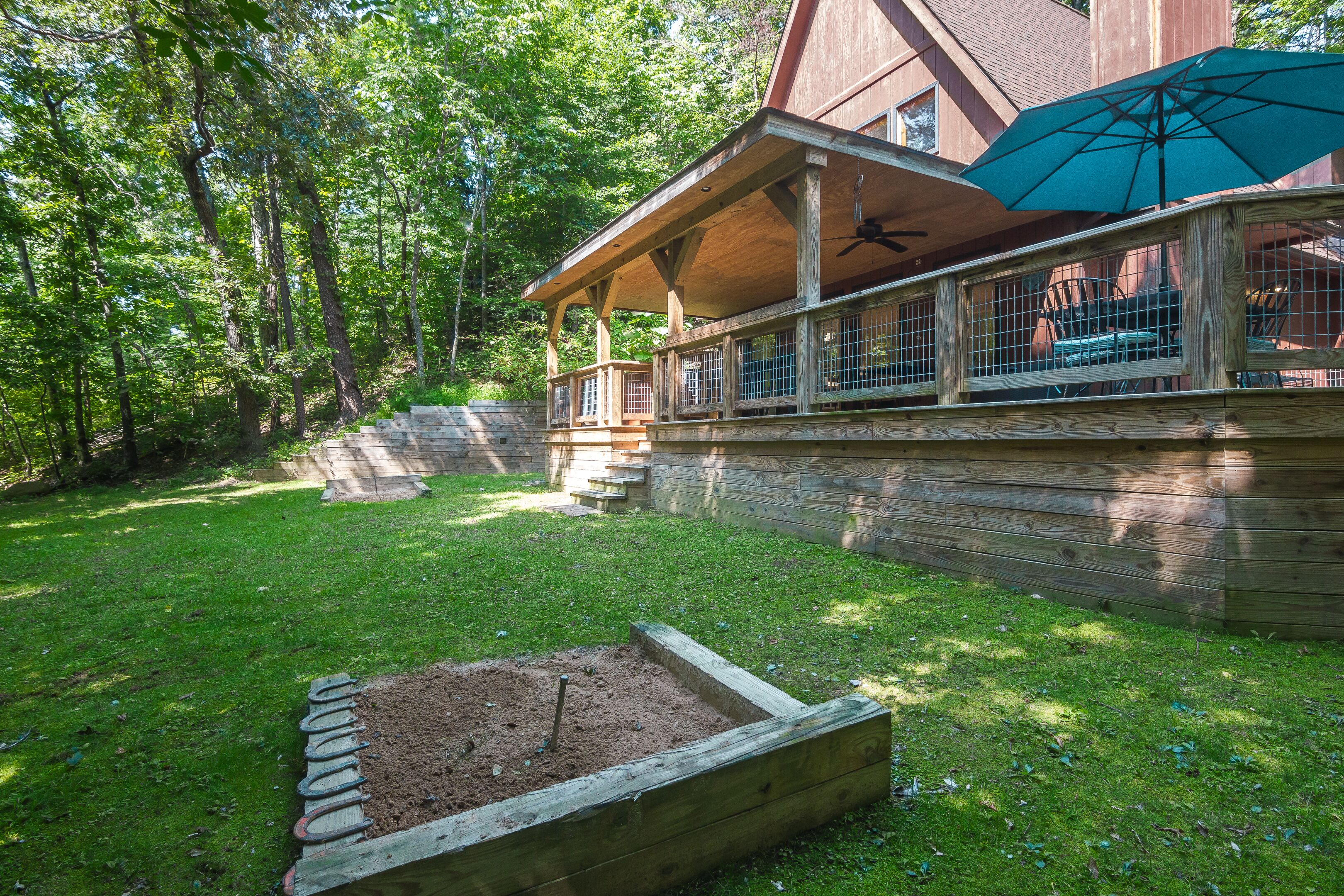 A wooden deck with a covered seating area, a raised garden bed, and a large umbrella.