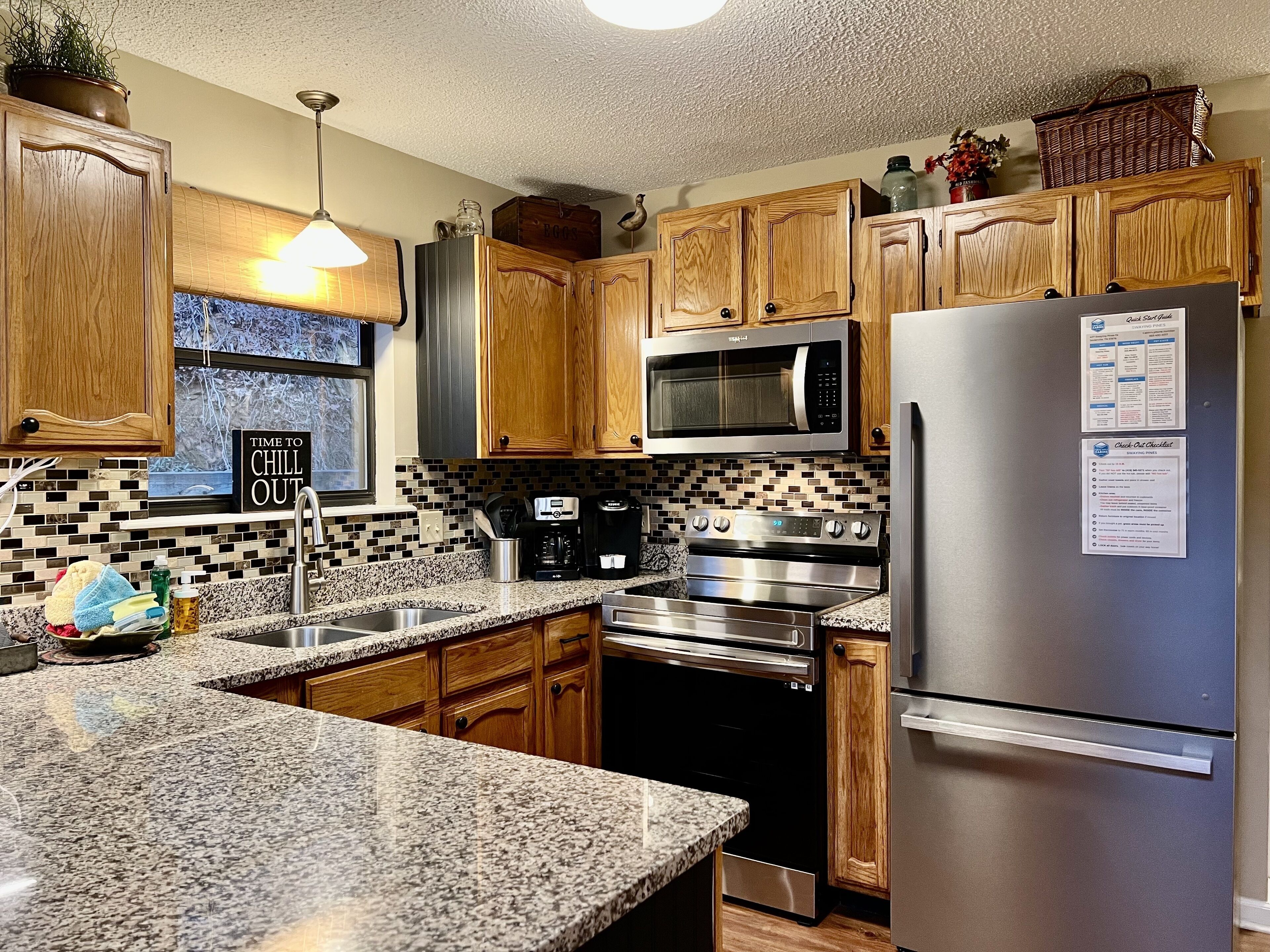 A kitchen with wooden cabinets, a stainless steel refrigerator, a microwave, and a coffee maker.