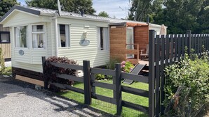 A mobile home with a fenced backyard, a small deck, and a satellite dish. - Mobile home Cadzand-Bad / Retranchement (Retranchement)