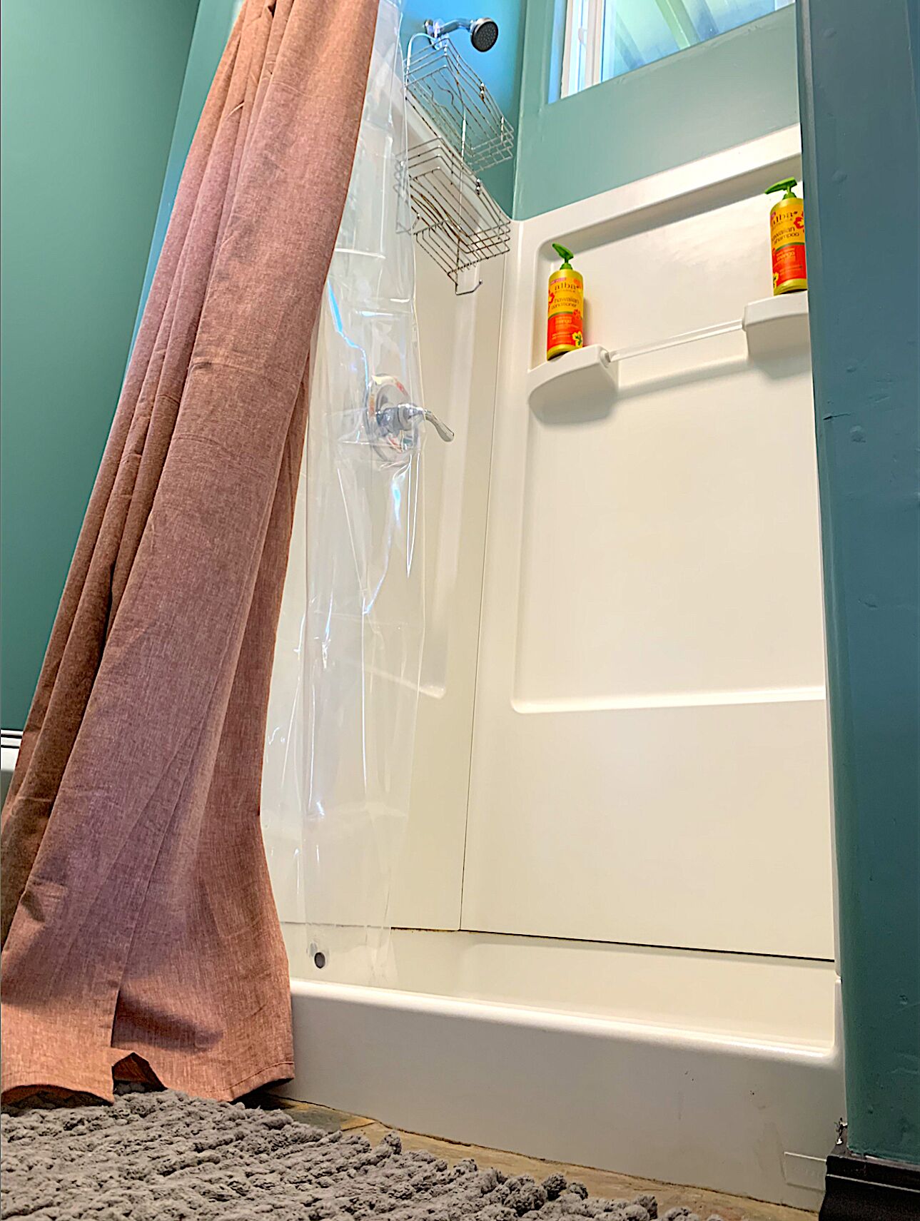 Baño con bañera, ducha y perchero para toallas.