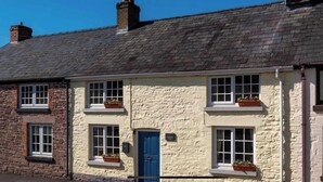 Una hilera de casas de piedra tradicionales con numerosas ventanas y una puerta azul.