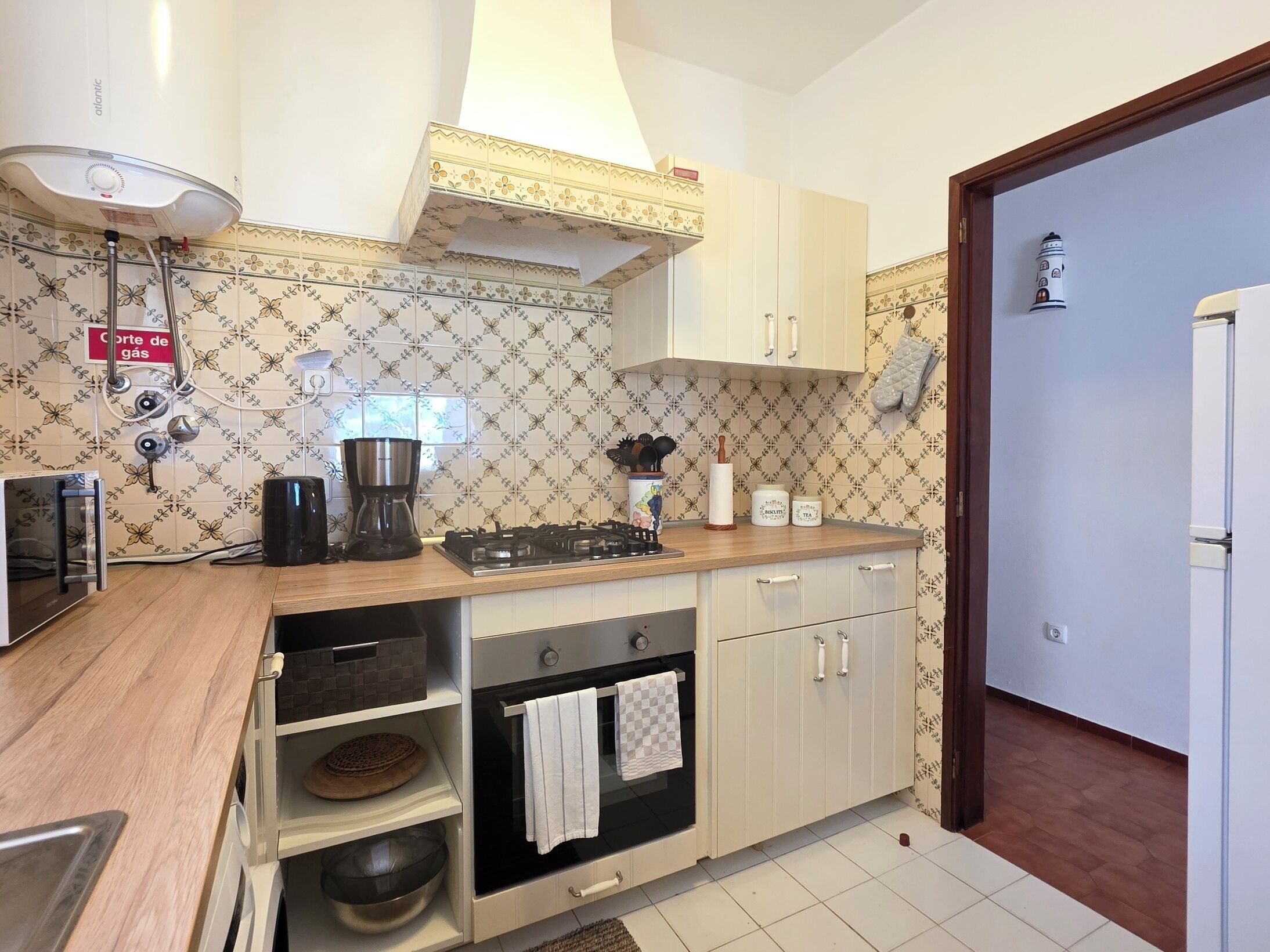 A kitchen with a gas stove, oven, microwave, and a coffee maker.
