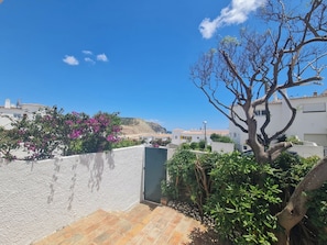 Stroll through a serene residential area surrounded by homes with red-tiled roofs and a tree-lined landscape.