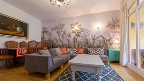 Een zithoek met een bank, stoelen, een salontafel en een eettafel.