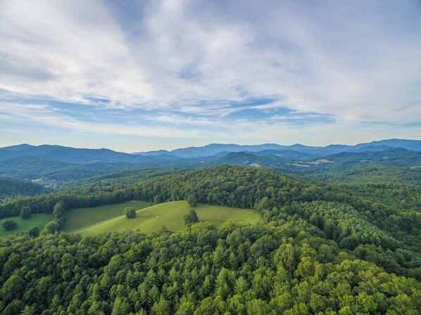A panoramic view of a mountainous landscape with dense forests and rolling hills.