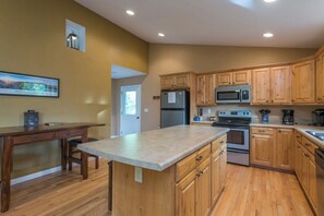 A kitchen with wooden cabinets, a granite countertop, a refrigerator, a microwave, and an oven. - Hot Tub+Fire Pit, Grill, Fireplace, WiFi, Private! (Burnsville)