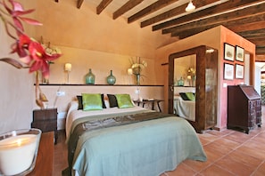 A bedroom with a bed, bedside tables, a dresser, and a mirror.