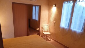 A room with a bed, a chair, a door, and a window. - House / Villa - Porto vecchio (Porto-Vecchio)