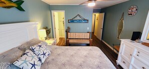 Une chambre à coucher comprenant un lit, des tables de chevet, un banc en bois et une commode.