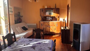 Een gezellige kamer met een bed, een klein tafeltje, een houten kast, een televisie en een open haard.