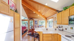 A spacious kitchen with wooden cabinets, a large island, and a view to the outside. - Fort Rock-Wonderful Sunriver Home,3BR-3.5BA- Hot Tub- Wifi-8 SHARC passes (Sunriver)