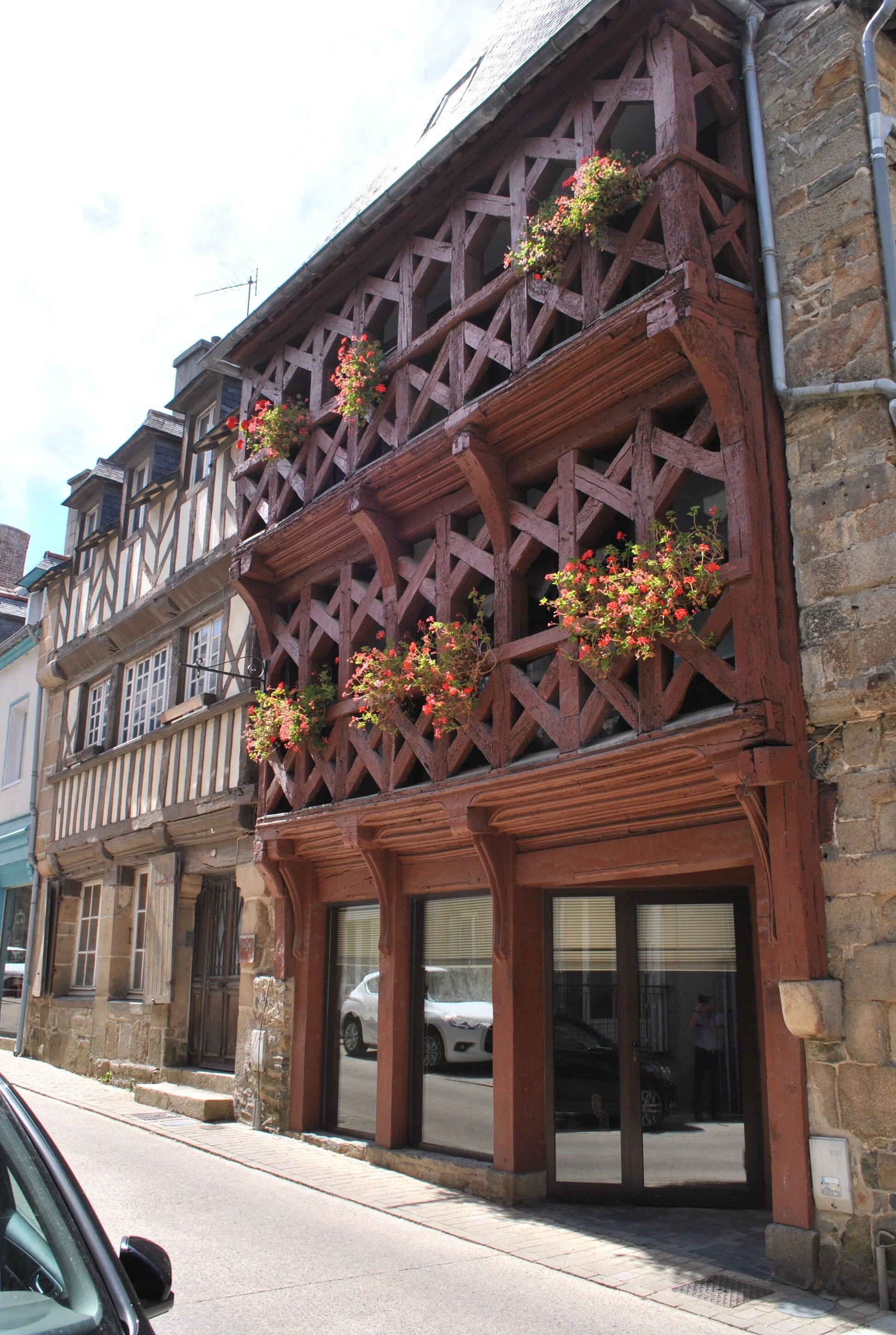 Ein traditionelles Fachwerkhäuschen mit Blumenkästen unter den Oberlichtern.