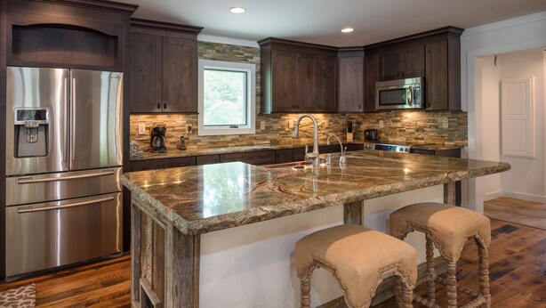 A modern kitchen with dark wood cabinets, stainless steel appliances, a granite countertop, and a window above the sink. - 36 Private Acres on the New River (Boone)