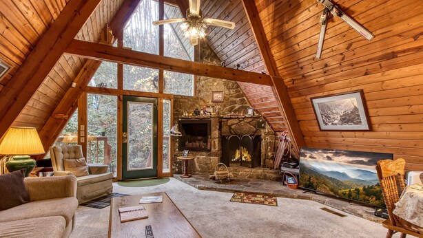 A cozy, wooden interior with a fireplace, a comfortable seating area, and a large window offering a scenic view. - 2 Miles to National Park or Downtown Gatlinburg! Less than1/2 mile to Ober! (Gatlinburg)