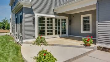 A two-story house with a covered patio, large windows, and a well-maintained lawn.