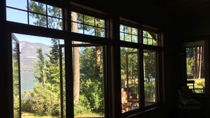 A room with large windows overlooking a lake and forest. - The Most Beautiful House on Flathead Lake - NW Travel Magazine 'Best Waterfront' (Polson)
