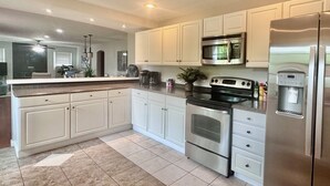 A modern kitchen with white cabinets, stainless steel appliances, and a built-in water dispenser. - Five Star Home 2 miles from Biltmore Estate  (Asheville)
