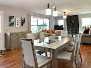 Enjoy a spacious dining area with a large table and comfortable chairs, a cozy seating area with a sofa and cushions, and a kitchen with an oven and microwave.
