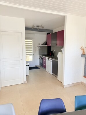 A compact kitchen with a refrigerator, stove, and cabinets.