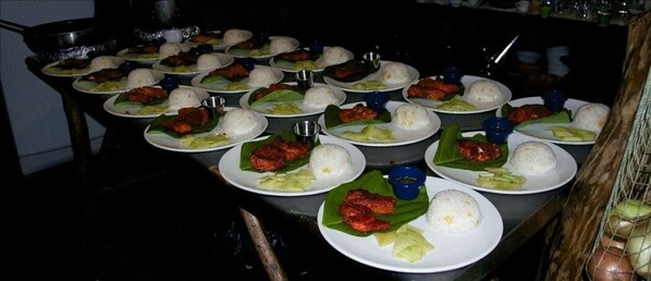 A table with multiple plates of food, including rice and various dishes, likely in a dining area.