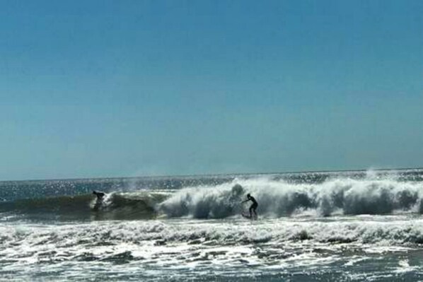 A beach with waves and a person surfing. - Private Room in Playa Grande #1 (Playa Grande)