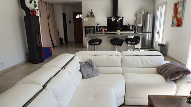A modern living room with a white sectional sofa, a glass-top coffee table, and a kitchen area in the background. - HOUSE WITH SWIMMING POOL, 4km from the sea, sleeps 8 (La Seyne-Sur-Mer)