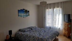 A bedroom with a bed, a TV, a lamp, and a painting on the wall. - HOUSE WITH SWIMMING POOL, 4km from the sea, sleeps 8 (La Seyne-Sur-Mer)