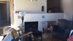 A cozy living room with a fireplace, wooden furniture, and a rustic decor. - Peaceful & Roomy - Very close walk (5 Blk) to Historic Plaza dining & shopping (Taos)