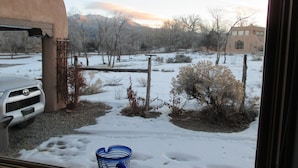 A snowy landscape with a parked car and a building in the background. - Peaceful & Roomy - Very close walk (5 Blk) to Historic Plaza dining & shopping (Taos)