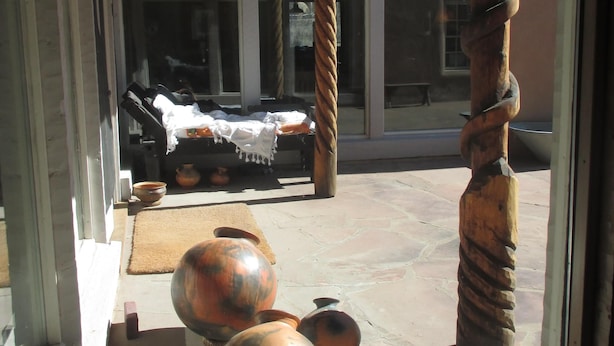 A covered outdoor area with a wooden ceiling, large windows, and a view of a building in the background. - Peaceful & Roomy - Very close walk (5 Blk) to Historic Plaza dining & shopping (Taos)