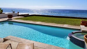 A rectangular swimming pool with clear blue water, surrounded by a tiled deck and a grassy area. -  REMODELED OCEANFRONT HOME WITH PRIVATE POOL AND HOT TUB (Playas de Rosarito)