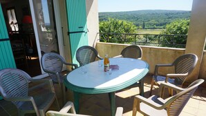 A round table with chairs on a balcony with a view of a green landscape. - Separate gite without immediate neighbour on laid out field, a lot of space... (Les Granges-Gontardes)