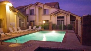 A swimming pool with lounge chairs and a building in the background. - Your Perfect Getaway Awaits- Ideal for Students and Families (Chandler)
