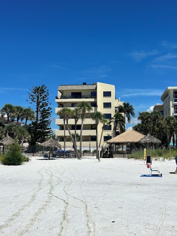 A beachfront hotel with multiple floors, palm trees, and thatched umbrellas. - Crescent Beach Escape – 2BR Beachfront Condo on Siesta Key
Steps to the sand! (Siesta Key)