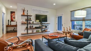 A modern living room with a flat-screen TV, a coffee table, a sofa, and a fireplace.