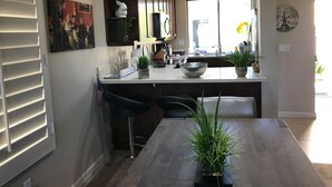 Une cuisine moderne dotée d’un îlot central, de tabourets de bar et d’une table à manger.