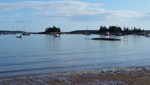 A calm harbor with boats and a rocky shoreline.