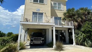A two-story house with a covered garage and a balcony. - Spectacular Gulf Front Home - Pool, Dock, Incredible Gulf View (Marathon)