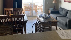 A living room with a dining area, a ceiling fan, a sofa, and a view through a glass door to an outdoor patio. - Spectacular Gulf Front Home - Pool, Dock, Incredible Gulf View (Marathon)