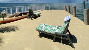 A sunny deck with lounge chairs and a kayak, overlooking the sea. - Spectacular Gulf Front Home - Pool, Dock, Incredible Gulf View (Marathon)