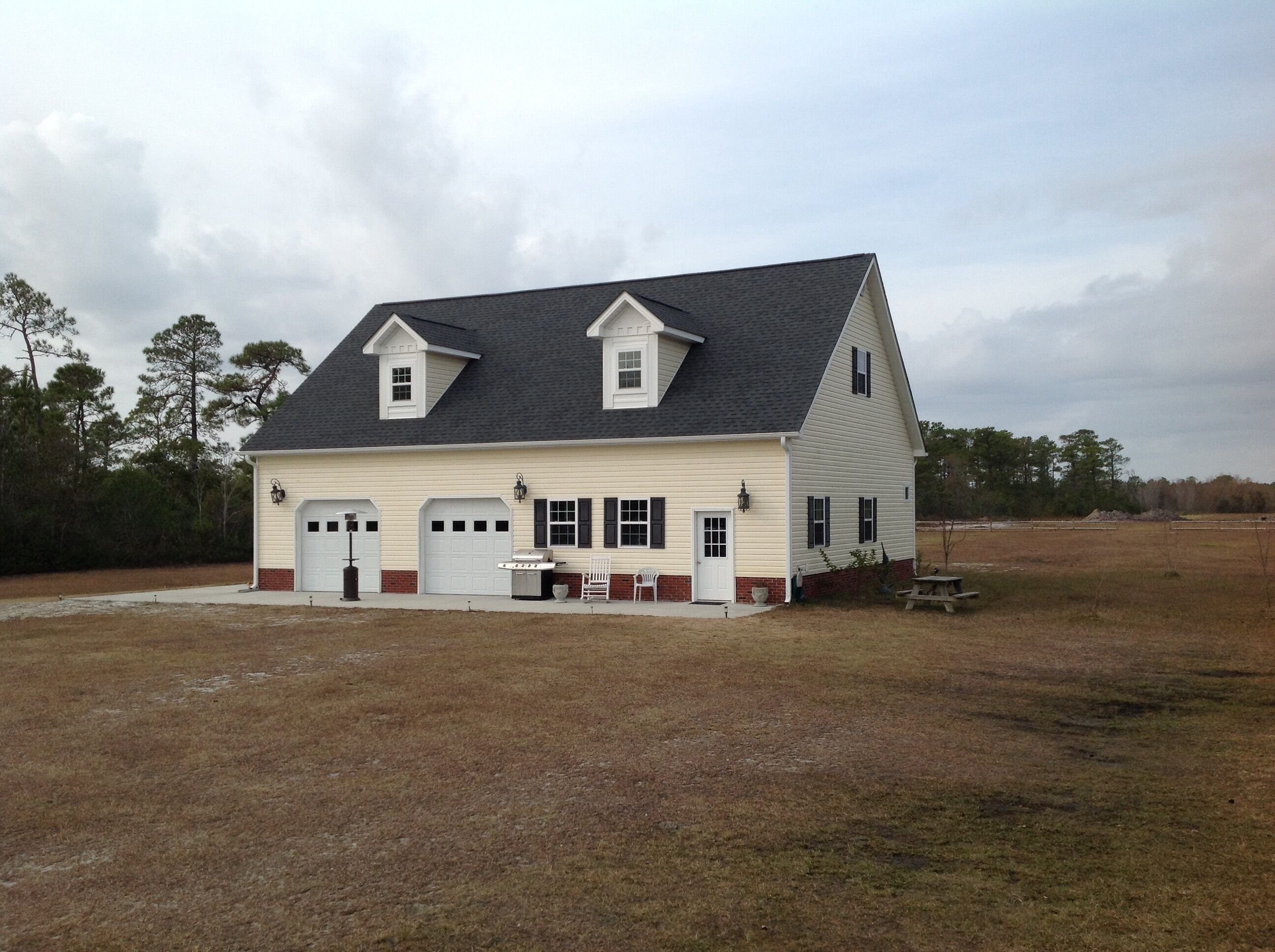 A two-story house with a gabled roof, a front porch, and a garage.